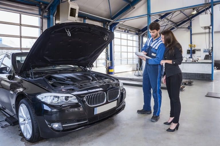 A mechanic going through a clipboard with a customer